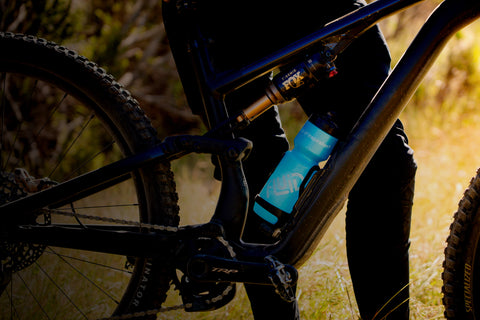 Close-up of a mountain bike with a focus on the suspension fork in a natural setting.