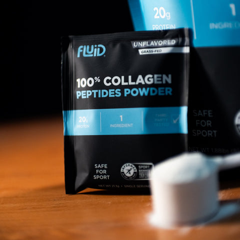 Two packages of Fluid 100% Collagen Peptides Powder on a wooden surface with a blurred white object in the foreground.