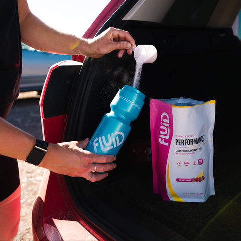 Person placing FLUID products into a car trunk