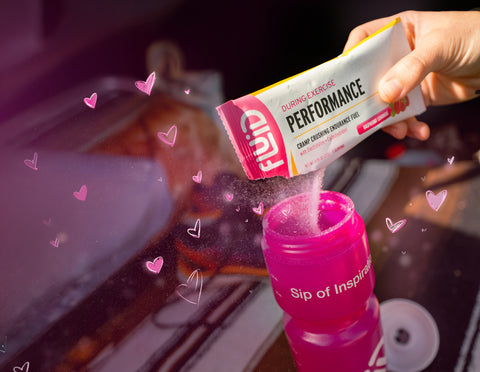 Pink Performance Raspberry Lemonade single packet being poured into a pink sports bottle 