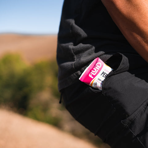 Person wearing a black jacket with a visible 'Flux' product label outdoors.
