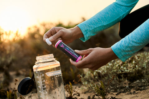 Fluid Tactical Electrolyte Tablet prepared to be dropped into a Nalgene bottle.